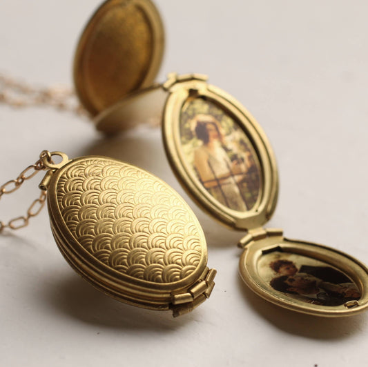Gold locket with engraved design on a light background